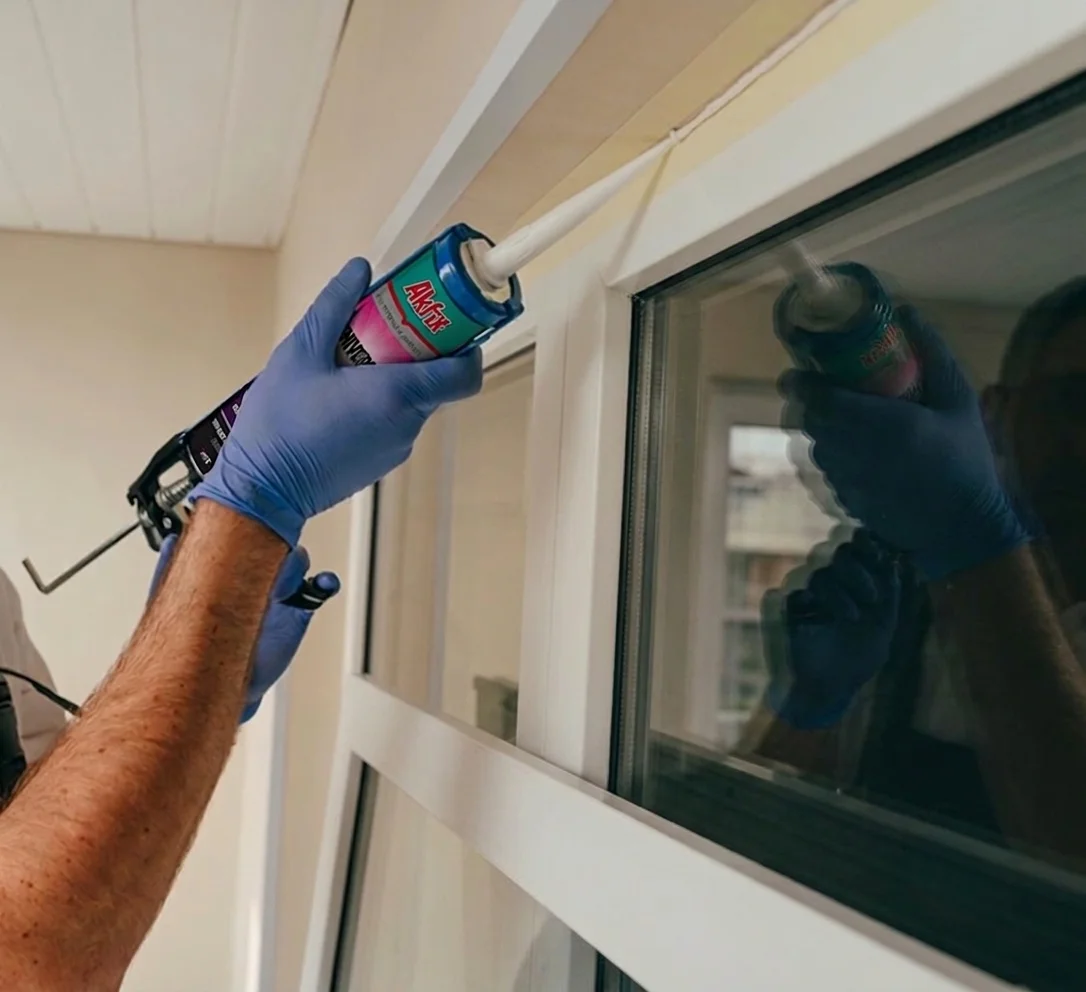 Aplicación de silicona Akfix en el marco de una ventana con pistola calafateadora, sellado de ventanas paso a paso